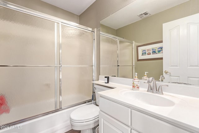 full bathroom with vanity, enclosed tub / shower combo, and toilet