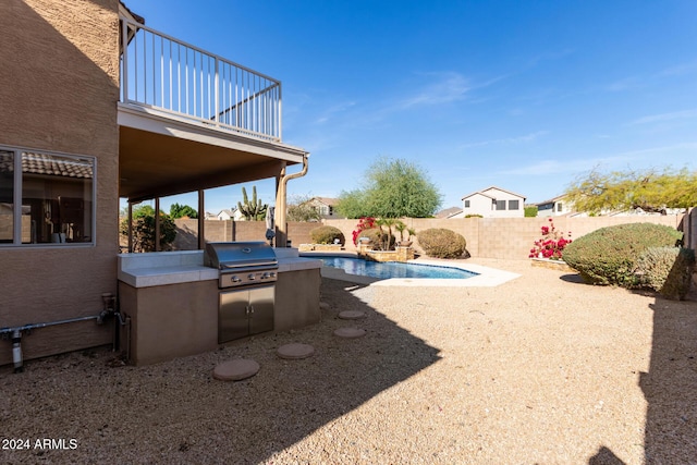 view of yard featuring a fenced in pool, a balcony, and exterior kitchen