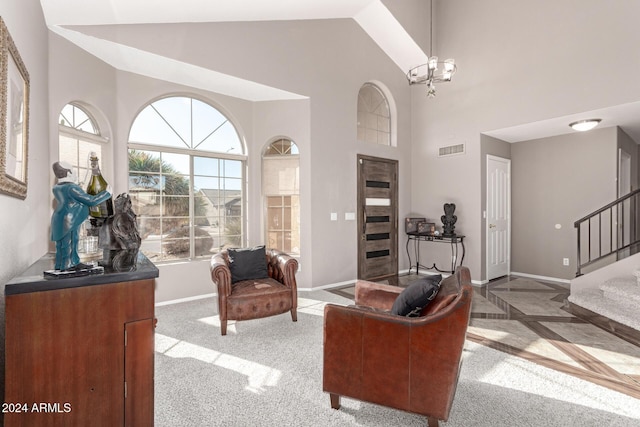 carpeted living room featuring a chandelier and high vaulted ceiling