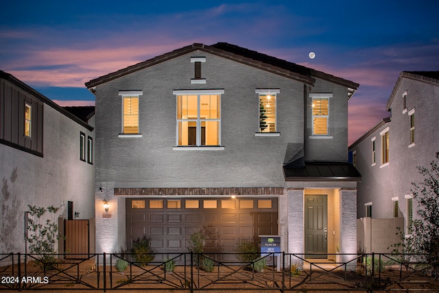 view of front of house with a standing seam roof, fence, metal roof, and stucco siding