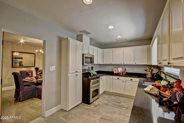 kitchen with appliances with stainless steel finishes, white cabinets, a sink, and visible vents