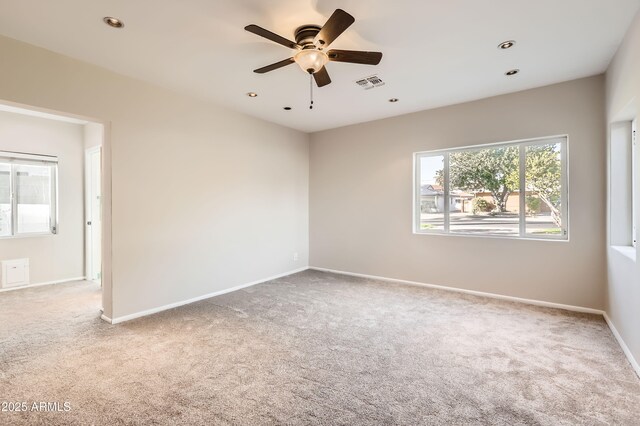 carpeted spare room with a ceiling fan, recessed lighting, visible vents, and baseboards