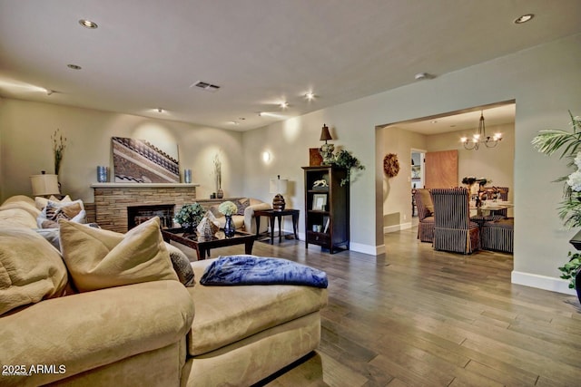 living area featuring baseboards, a fireplace, visible vents, and wood finished floors