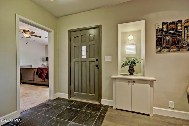 entryway featuring ceiling fan and baseboards