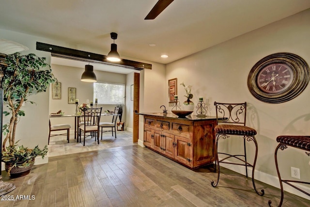 interior space featuring baseboards, ceiling fan, light wood-style floors, pendant lighting, and recessed lighting