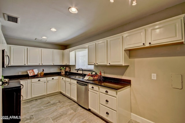 kitchen featuring visible vents, white cabinets, dark countertops, stainless steel dishwasher, and a sink