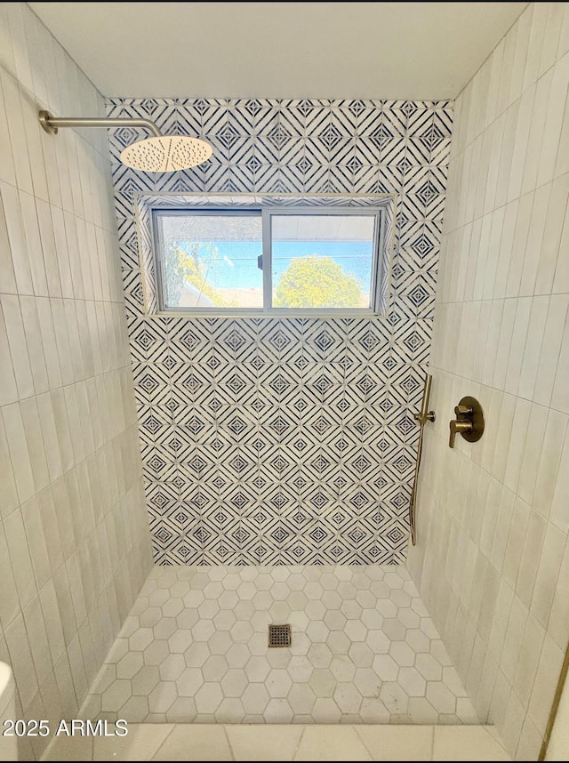 bathroom with a healthy amount of sunlight and tiled shower