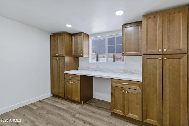 kitchen featuring built in desk and light hardwood / wood-style flooring