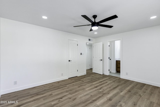 unfurnished bedroom featuring ceiling fan, wood-type flooring, and ensuite bathroom