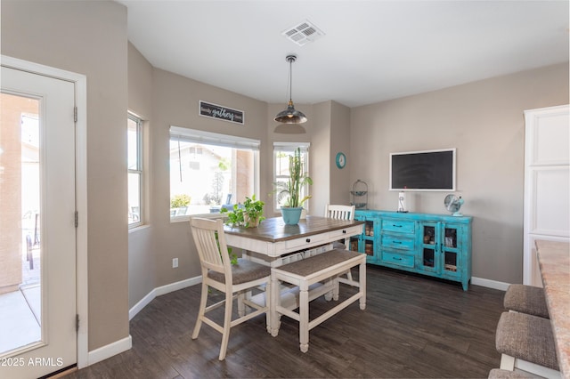 dining space featuring dark wood-style flooring, visible vents, and baseboards