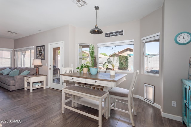 dining space with a healthy amount of sunlight, visible vents, and wood finished floors