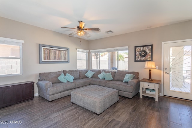 living room with dark wood-type flooring, visible vents, and ceiling fan