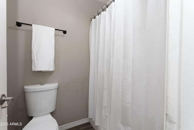 bathroom with toilet and baseboards