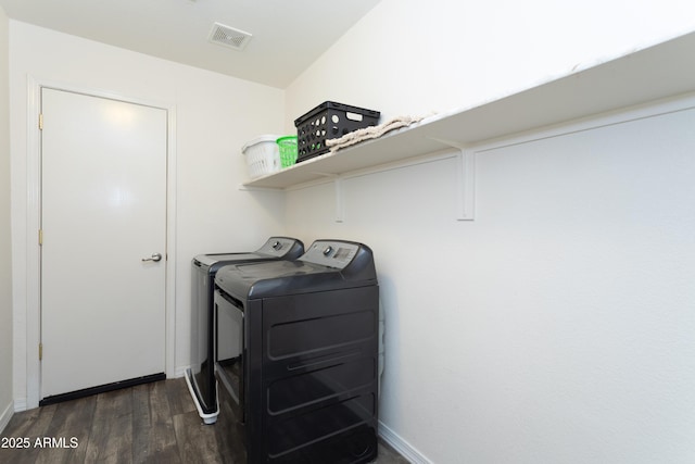 clothes washing area with visible vents, baseboards, separate washer and dryer, laundry area, and dark wood-type flooring