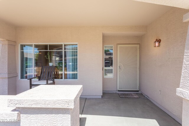 entrance to property with a patio area and stucco siding