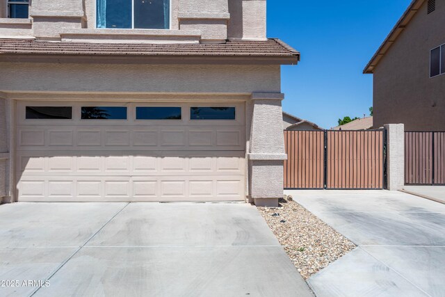 garage featuring a gate and driveway