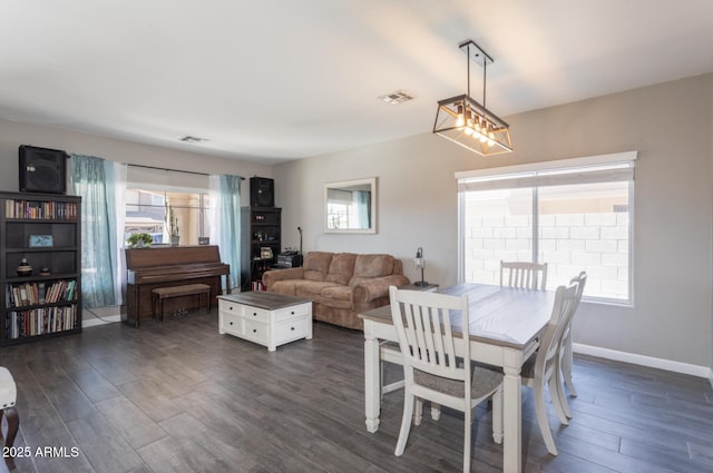 dining area with dark wood-style floors, baseboards, and visible vents