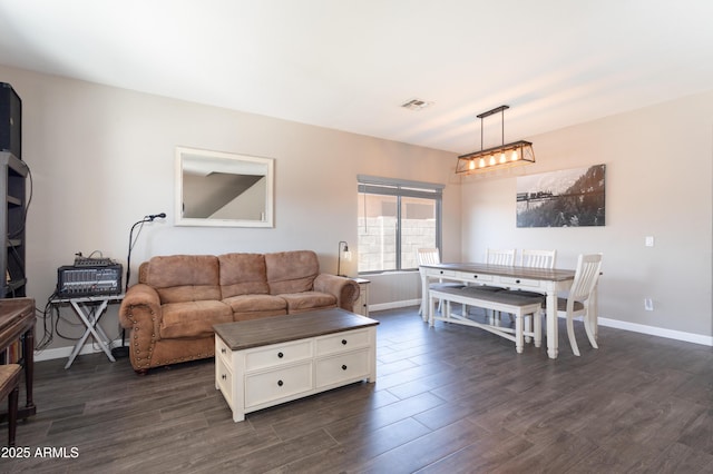 living room featuring dark wood-type flooring, visible vents, and baseboards