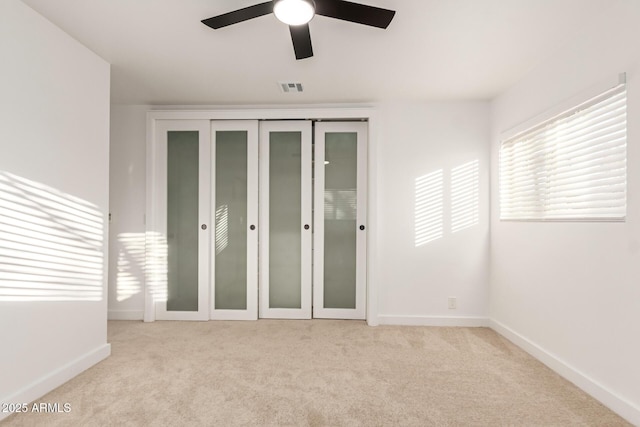 unfurnished room featuring light colored carpet and ceiling fan