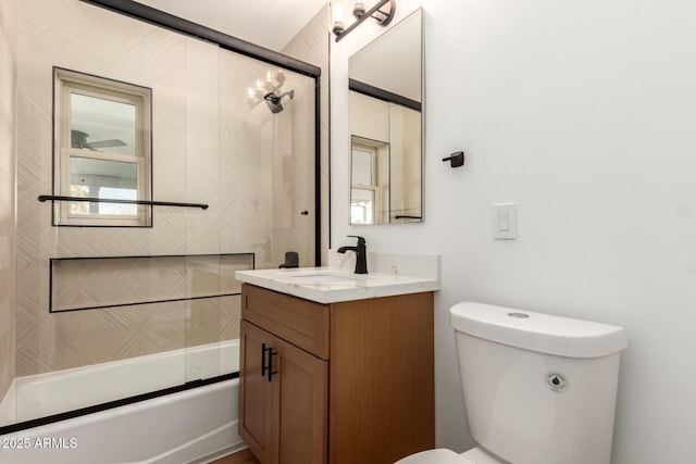 full bathroom with combined bath / shower with glass door, vanity, and toilet