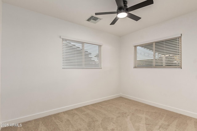 spare room featuring light carpet and ceiling fan