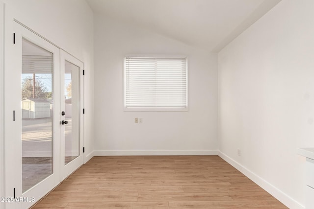 interior space featuring vaulted ceiling, french doors, and light hardwood / wood-style floors