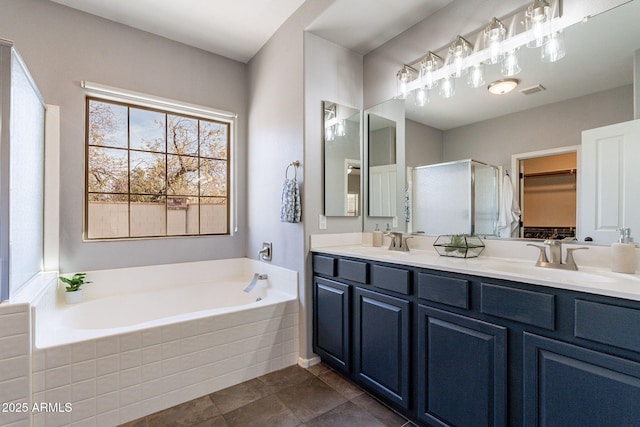 bathroom with vanity and shower with separate bathtub