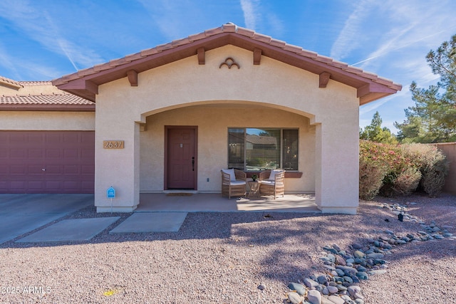 view of front of home with a garage and a patio