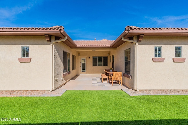 rear view of property featuring a yard and a patio area