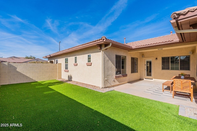 back of house featuring a yard and a patio area