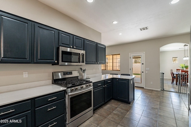 kitchen with stainless steel appliances, light tile patterned floors, and kitchen peninsula