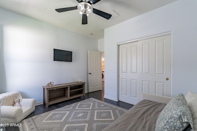 bedroom with dark hardwood / wood-style flooring, a closet, and ceiling fan