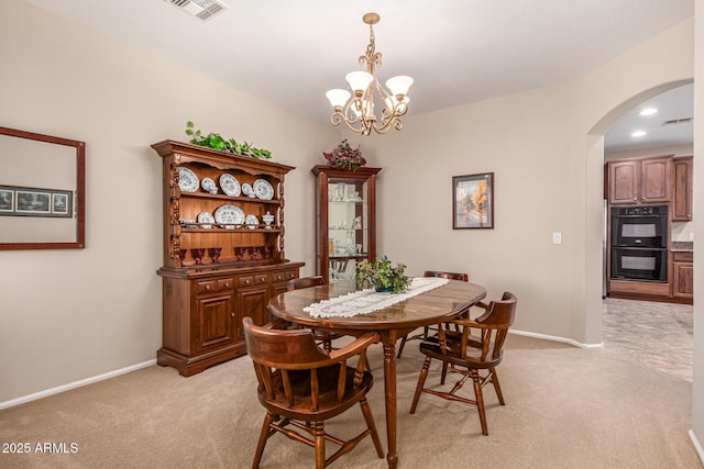 carpeted dining space featuring an inviting chandelier