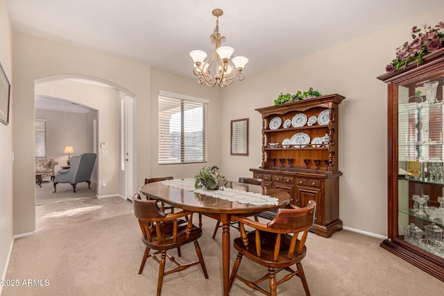 carpeted dining room with a notable chandelier