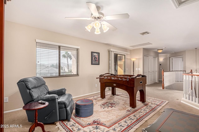 rec room with ceiling fan and light carpet