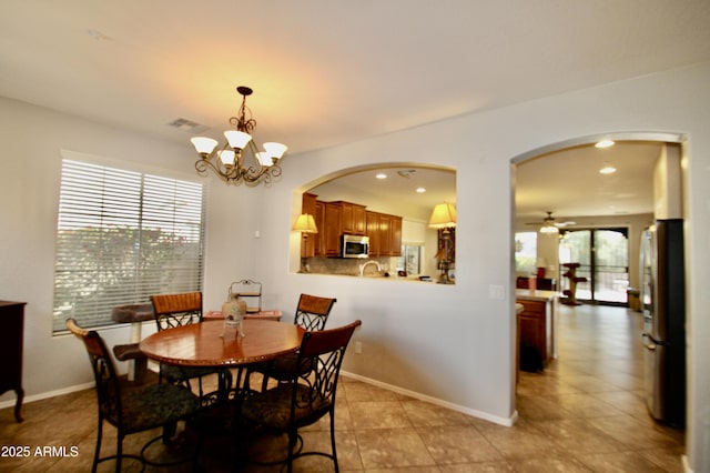 dining space featuring ceiling fan with notable chandelier and a wealth of natural light