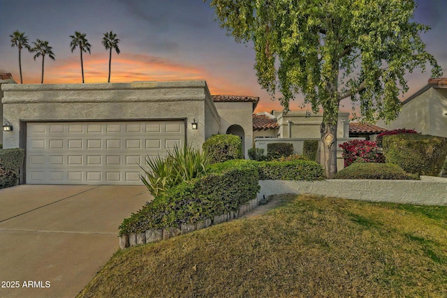 view of front of home with a garage and a lawn