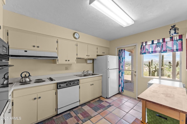 637 Chaparral Rd, Wickenburg, AZ 85390 - kitchen with a textured ceiling, a sink, light countertops, under cabinet range hood, and white appliances