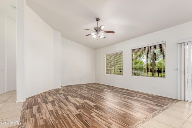 spare room with ceiling fan, a wealth of natural light, and light hardwood / wood-style floors