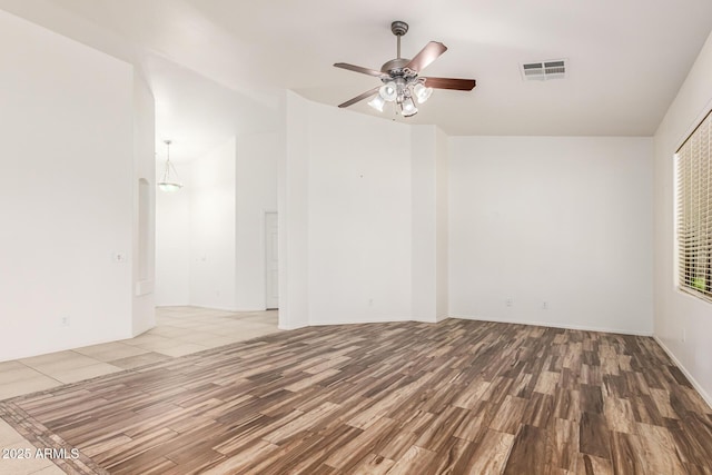 empty room with hardwood / wood-style flooring and ceiling fan