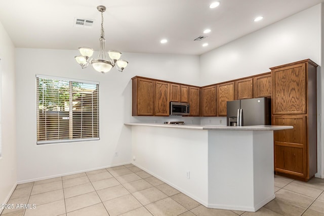 kitchen featuring an inviting chandelier, light tile patterned floors, appliances with stainless steel finishes, kitchen peninsula, and pendant lighting