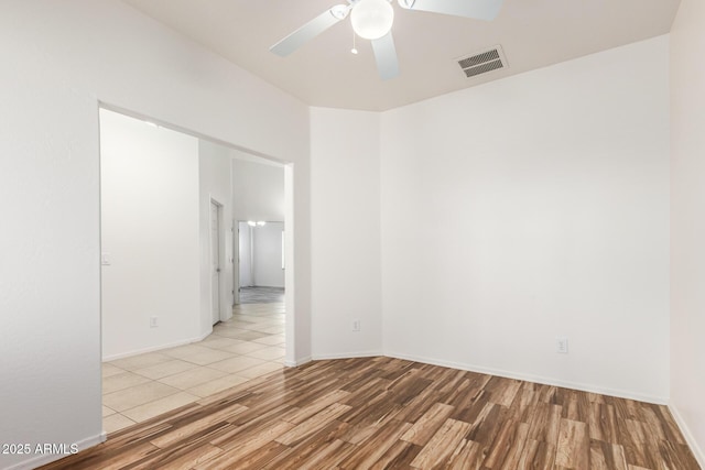 empty room with ceiling fan and light hardwood / wood-style floors