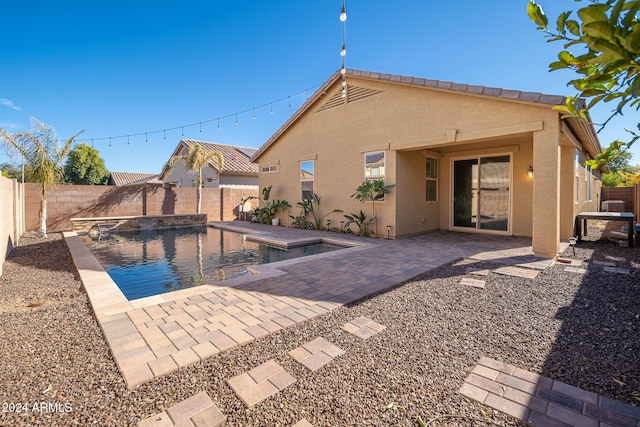 back of property featuring a fenced in pool and a patio area