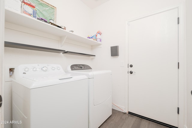 clothes washing area with independent washer and dryer and light wood-type flooring