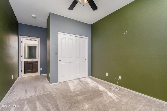 unfurnished bedroom with ceiling fan, light carpet, and a closet