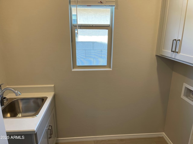 laundry room featuring cabinet space, hookup for a washing machine, and baseboards