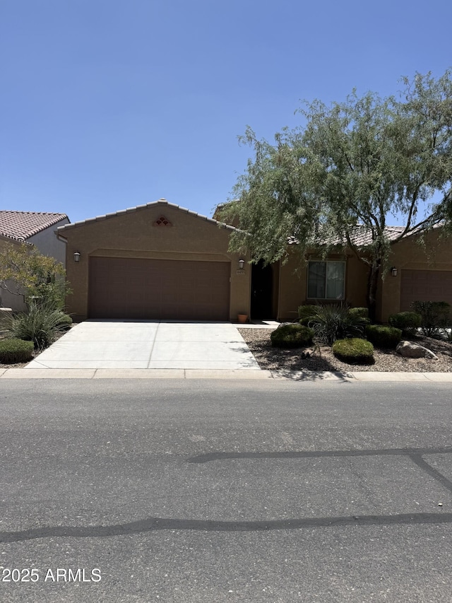 4455 W Hanna Dr, Eloy, AZ 85131 - pueblo-style home with an attached garage, driveway, and stucco siding