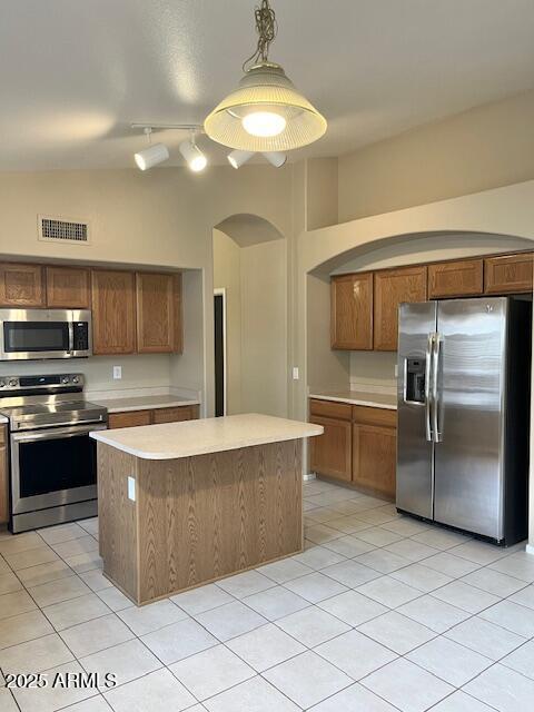 6376 W Adobe Dr, Glendale, AZ 85308 - kitchen featuring appliances with stainless steel finishes, light countertops, light tile patterned flooring, and a center island