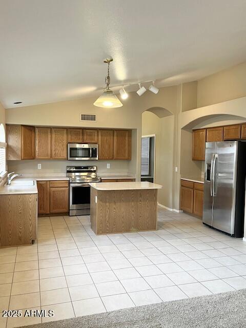 6376 W Adobe Dr, Glendale, AZ 85308 - kitchen featuring appliances with stainless steel finishes, arched walkways, a sink, a center island, and lofted ceiling
