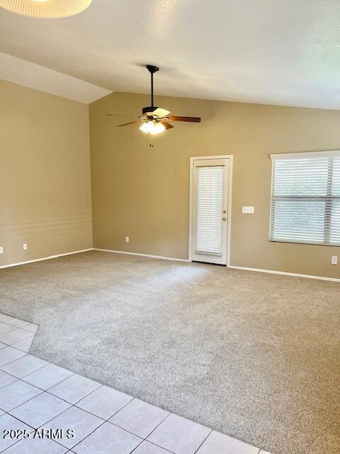 6376 W Adobe Dr, Glendale, AZ 85308 - spare room with light carpet, lofted ceiling, baseboards, a ceiling fan, and light tile patterned flooring